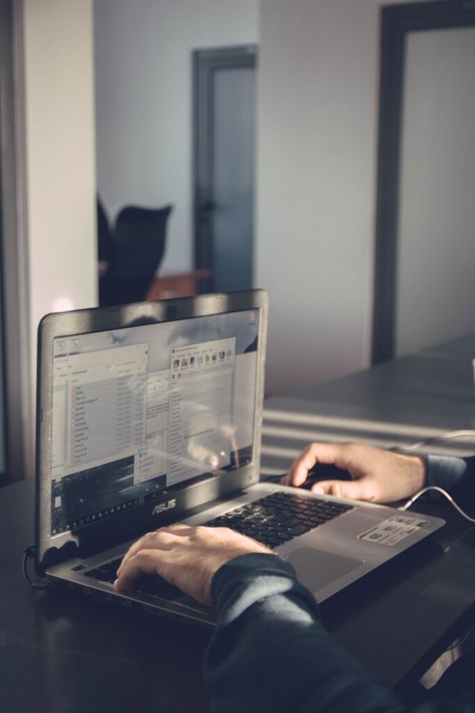 pexels photo 1604025 1604025 A person typing on a laptop inside an office, emphasizing technology and productivity.